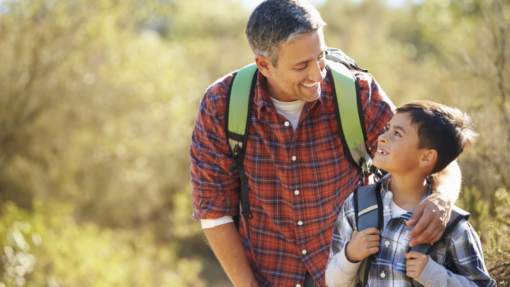 Father,And,Son,Hiking,In,Countryside,Wearing,Backpacks